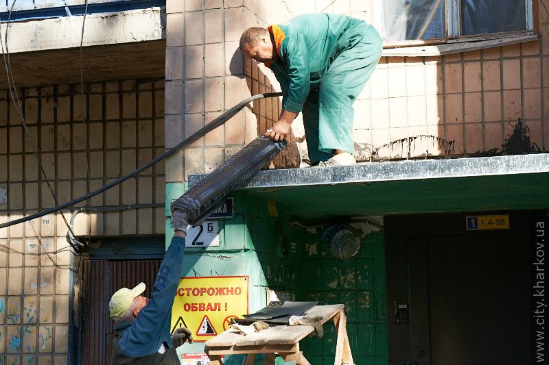 Поблизу пошкодженого вибухом будинку по Слинька впорядковують територію